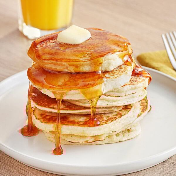 A stack of pancakes topped with butter and syrup on a white plate, made from Bob's Red Mill Gluten-Free Pancake Mix.