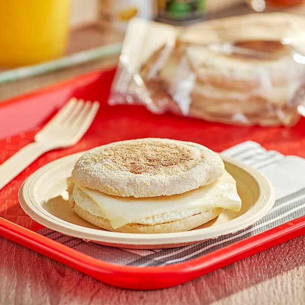 A Timber Ridge Farms breakfast sandwich with egg and Swiss cheese on a plate with a fork.