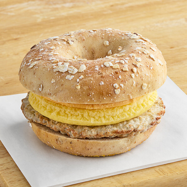 A Grand Prairie Sausage, Egg, and Cheese Bagel sandwich on a white background.