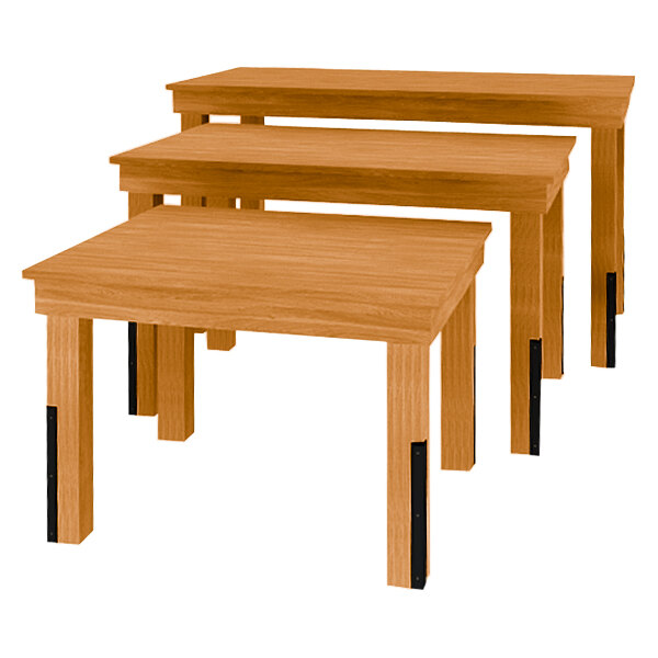 A Marco Company three-piece nesting table set with honey pine wood surfaces and black legs.
