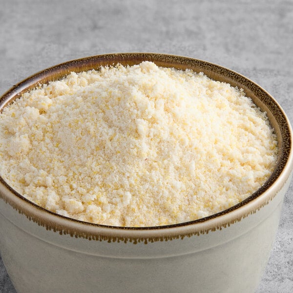 A bowl of Krusteaz Professional Honey Cornbread and Muffin Mix on a gray surface.