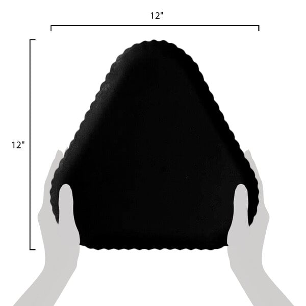 A hand holding a black triangular GET Mediterranean polycarbonate plate with a scalloped edge.