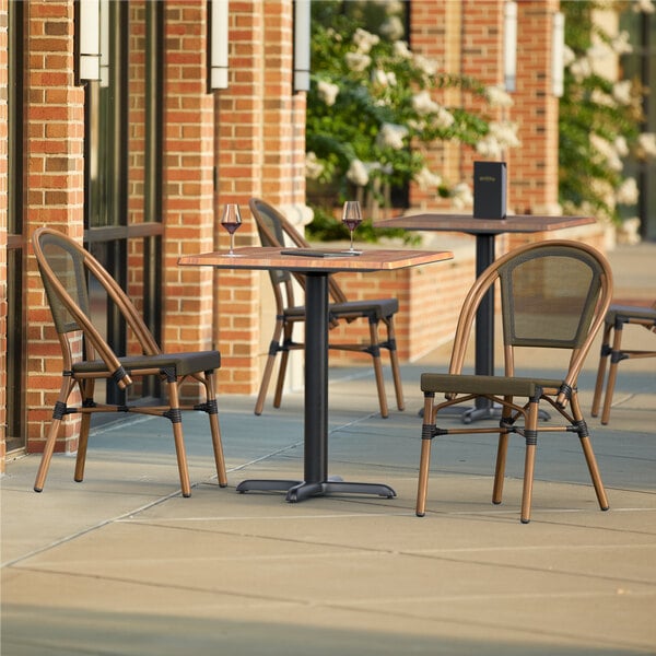 A Lancaster Table & Seating Yukon Oak table with 2 chairs on a stone patio.