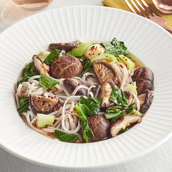 A white plate of noodles with Dried Whole Shiitake Mushrooms.