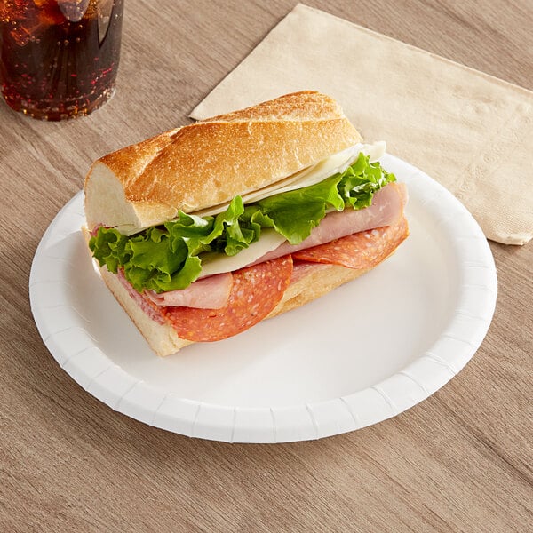 A sandwich with meat and cheese on a Choice paper plate.