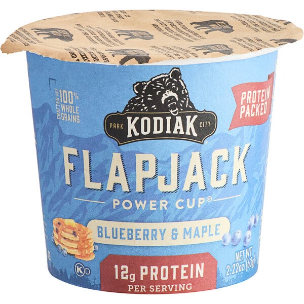 A blue and white Kodiak Cakes Blueberry and Maple Flapjack Cup on a table.