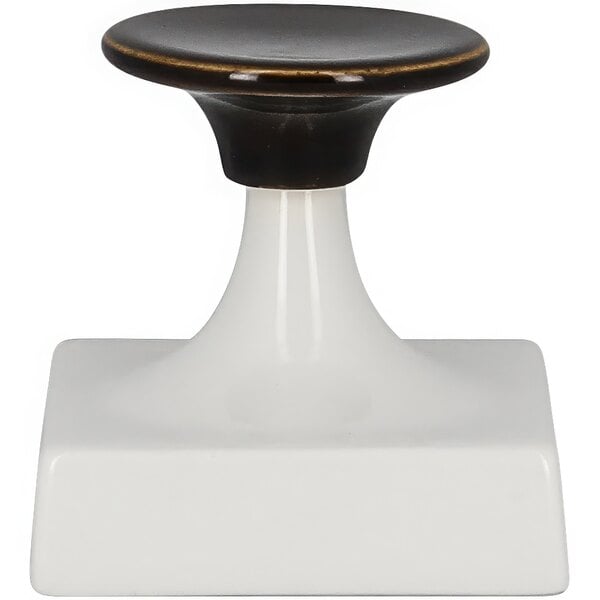 A white RAK Porcelain trumpet stand with a black and gold knob.
