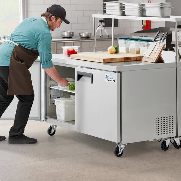 An Avantco undercounter refrigerator in a school kitchen.