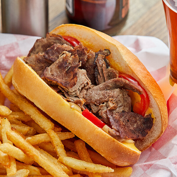 A sandwich with Original Philly Cheesesteak Co. beef and fries on a table.