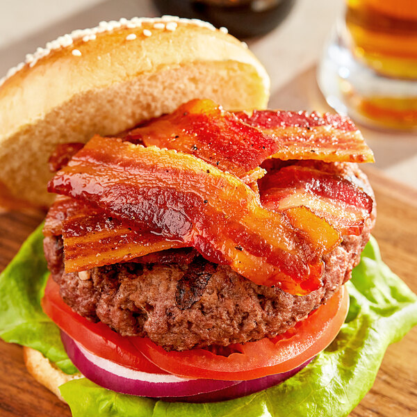 A close-up of a bacon sandwich on a wooden cutting board.