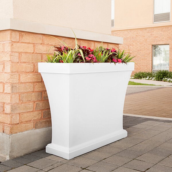 A white rectangular Mayne trough planter with flowers in it.