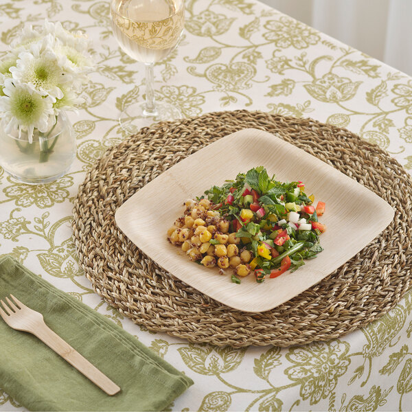 A Bambu square bamboo plate with food on it and a wooden fork on a table.
