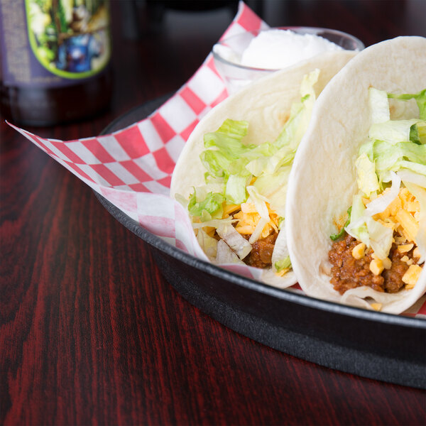 A pan of tacos in HS Inc. oval deli servers on a table in a Mexican restaurant.
