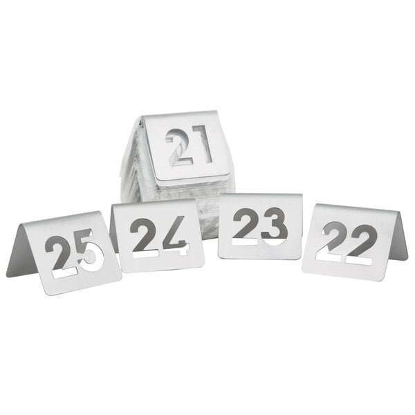 A group of Tablecraft stainless steel cut-out numbers on a white surface.