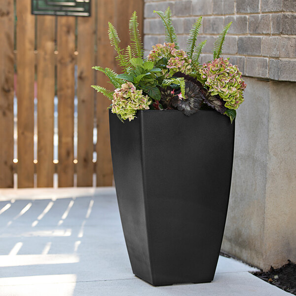 A black square Mayne Kobi planter with green plants.