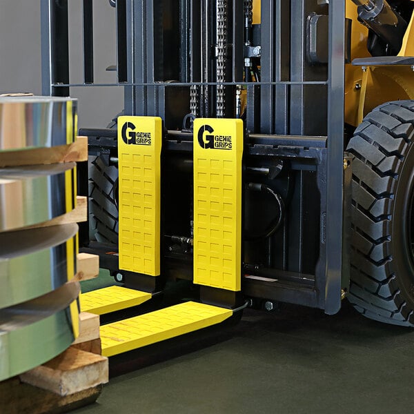 A forklift with yellow GenieGrips cushions on the forks.