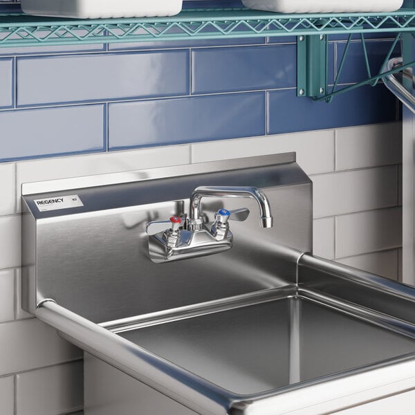 A stainless steel wall mount faucet with an 8-inch swing spout and 4-inch centers installed above a commercial sink.