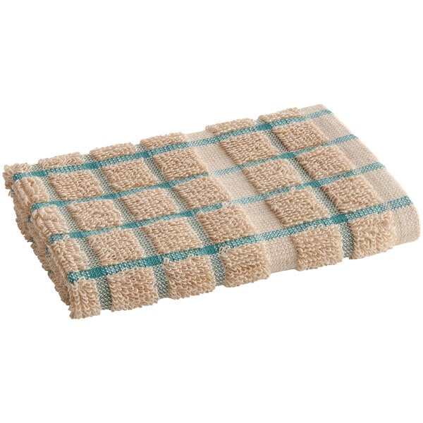 A tan dish cloth with a green windowpane design and blue stripe.