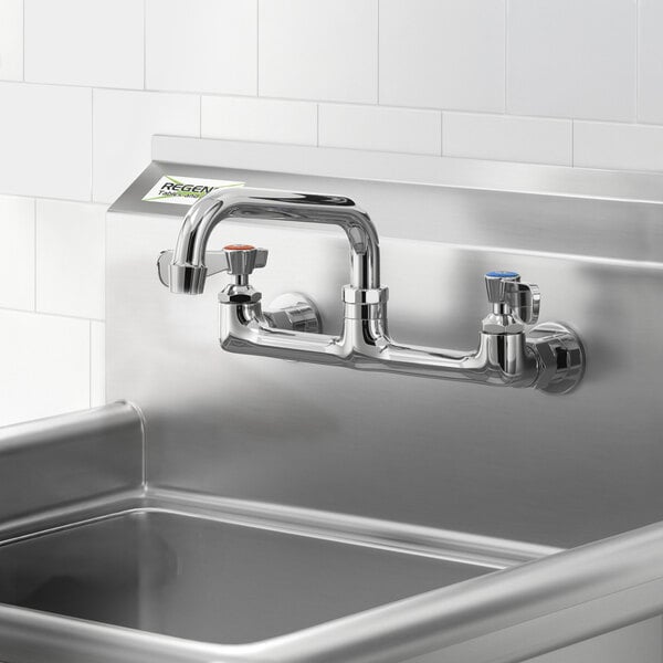 A wall-mounted faucet with 8-inch centers and a 6-inch swing spout installed above a stainless steel sink.