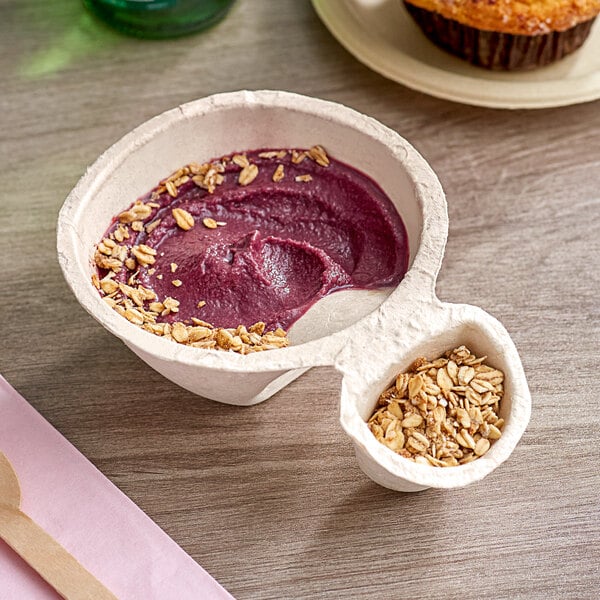 A bowl of Sambazon Acai with a wooden spoon on a pink napkin.