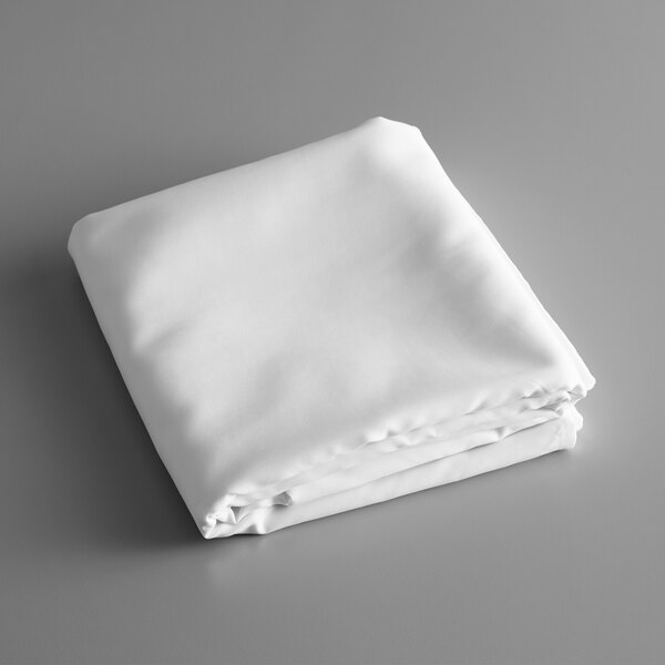 A folded white rectangular Intedge table cover on a gray surface.