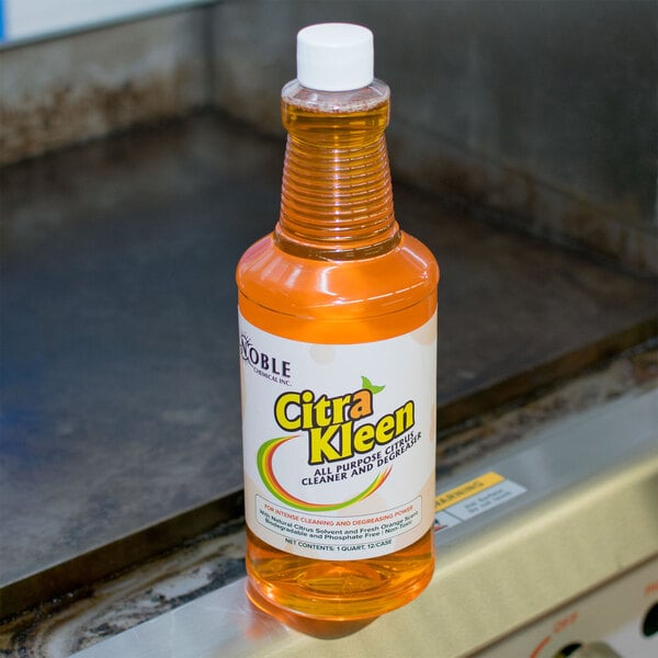 A bottle of Noble Chemical CitraKleen concentrated orange liquid on a counter.