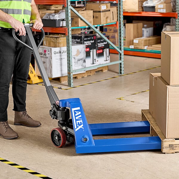 A man using a Lavex pallet jack in a warehouse.