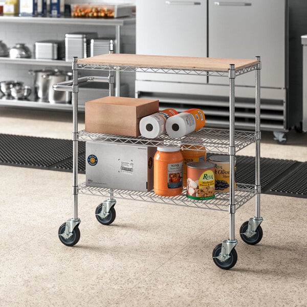 A Regency chrome utility cart with wooden shelves holding boxes and containers.