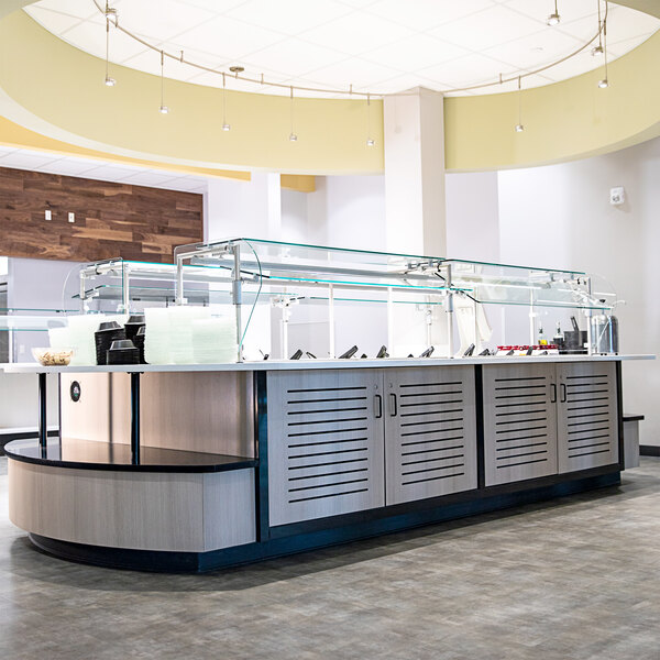 A Vollrath 6-Series custom front of house serving system on a counter with a glass top.
