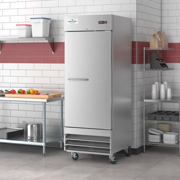 A stainless steel Main Street Equipment reach-in freezer with a handle in a school kitchen.