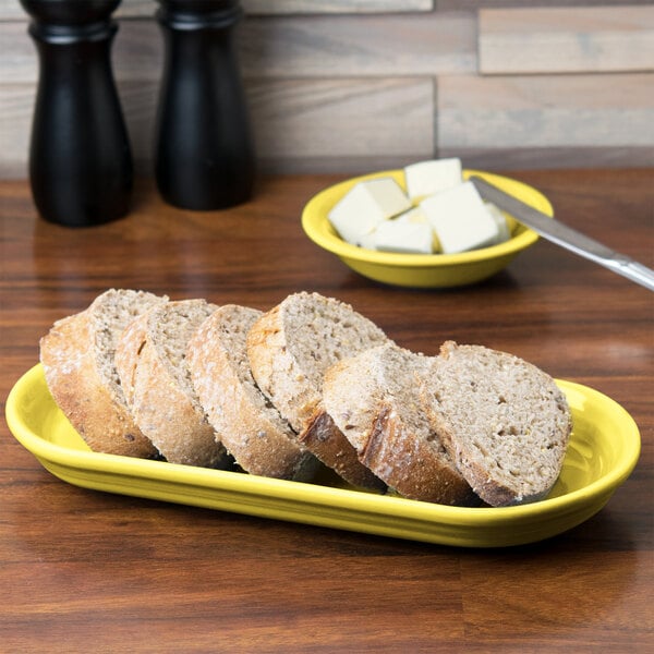 A Fiesta Sunflower oval china bread tray with slices of bread on it.