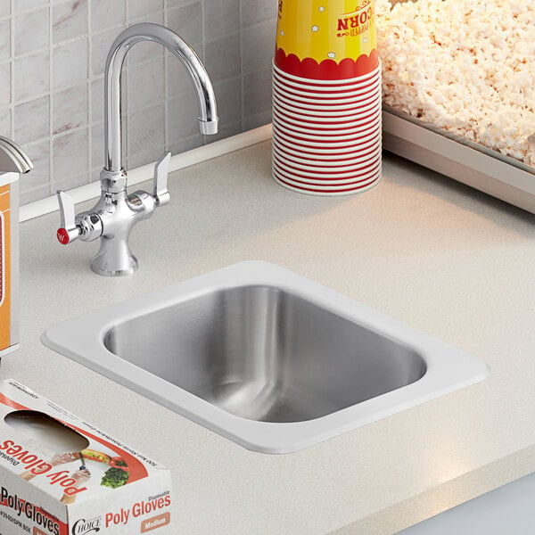 A close-up of a Regency stainless steel sink with a single compartment.