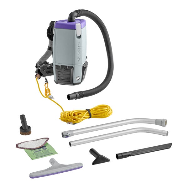 A ProTeam backpack vacuum with hose and tools on the floor.