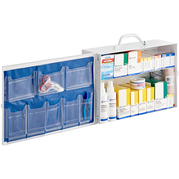 A white metal First Aid Only cabinet with blue and white first aid supplies inside.