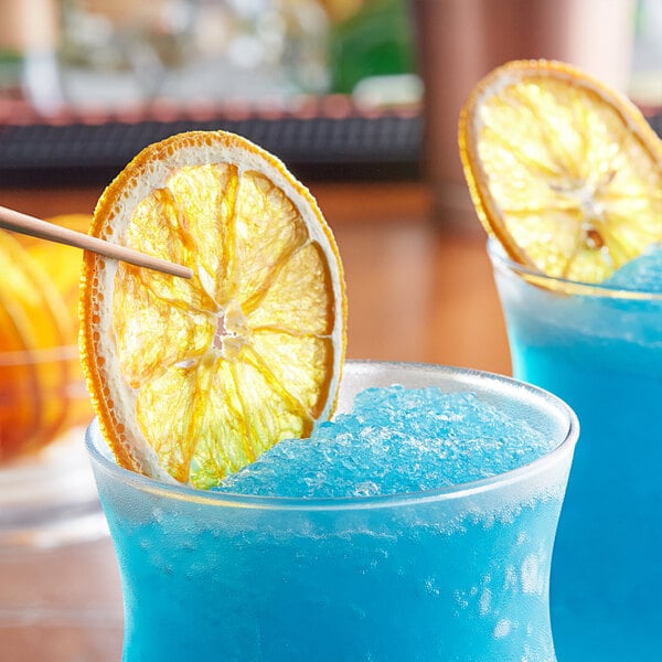 Two blue drinks with ice and dried navel orange slices.