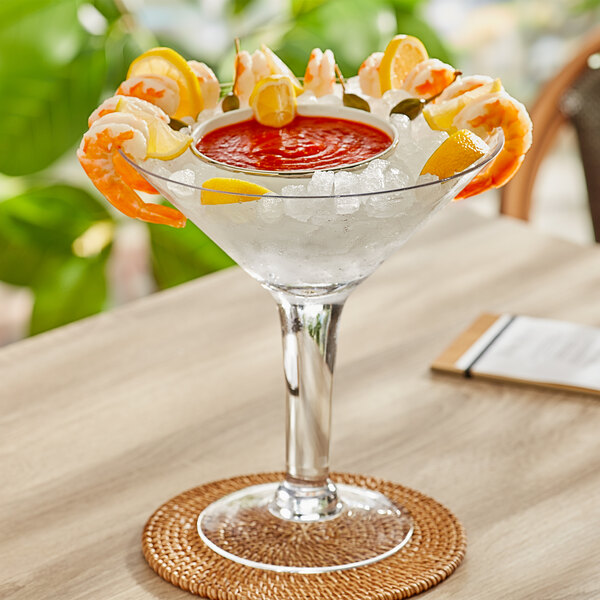 An Acopa martini glass filled with a shrimp and sauce on a table.