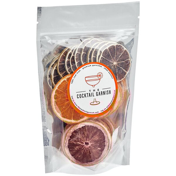 A bag of The Cocktail Garnish Dried Citrus Blend with dried orange slices and slices of oranges.