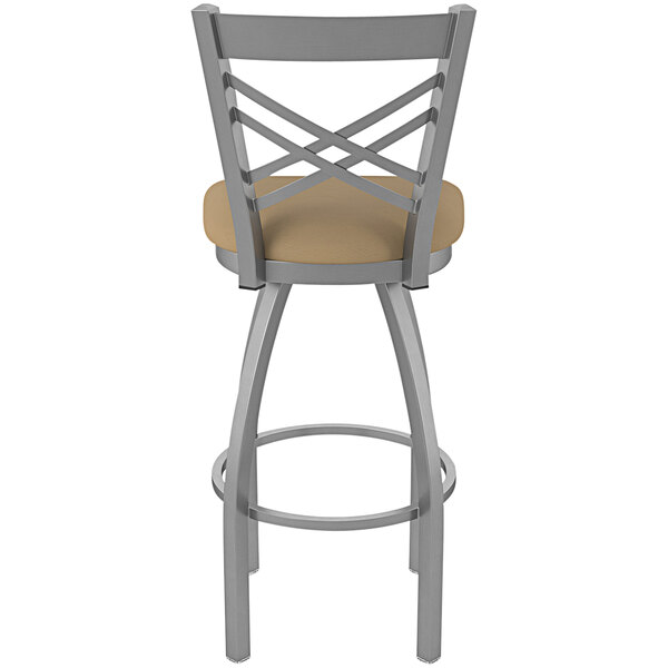 A Holland Bar Stool stainless steel outdoor extra tall bar stool with a tan cushion.