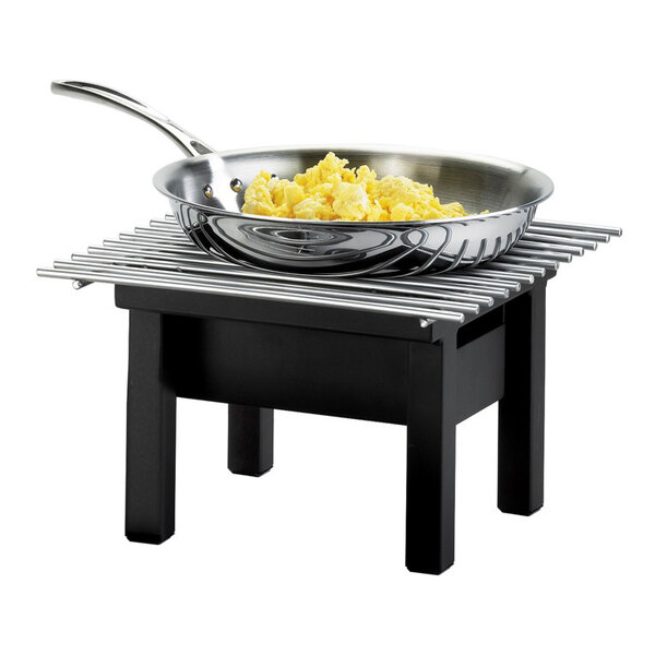 A black chafer griddle with a stainless steel pan containing scrambled eggs on top.