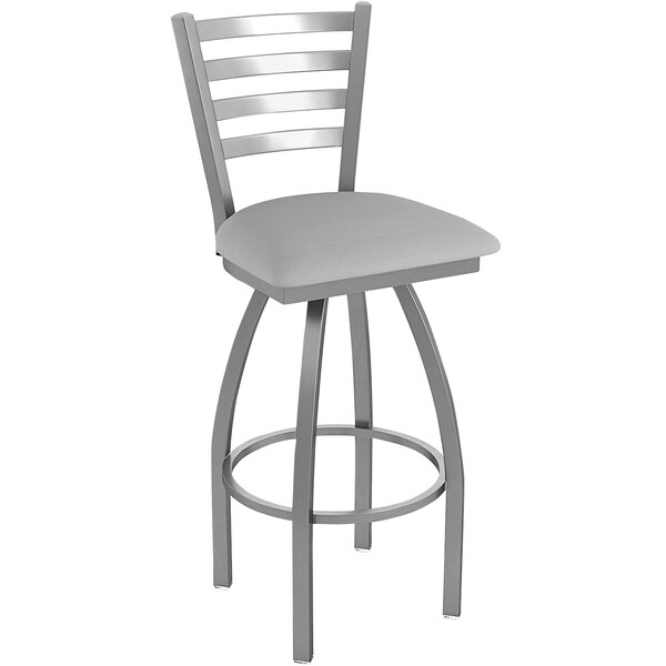 A Holland Bar Stool stainless steel outdoor extra tall bar stool with a ladderback and Breeze sidewalk seat in gray.