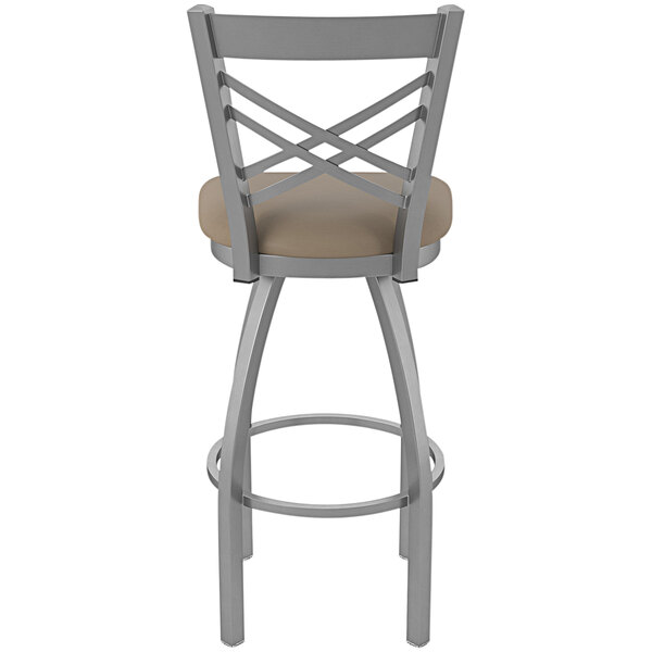 A Holland Bar Stool stainless steel outdoor extra tall bar stool with a tan cushioned seat.