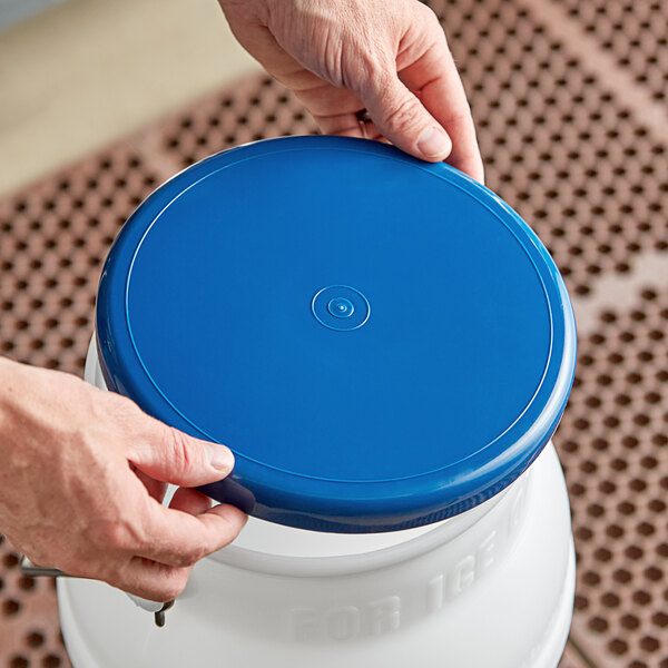 A person holding a blue Vigor ice tote lid.