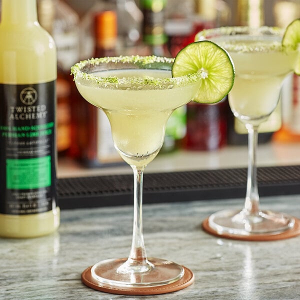 Two glasses of margaritas made with Twisted Alchemy Persian Lime Juice on a counter.