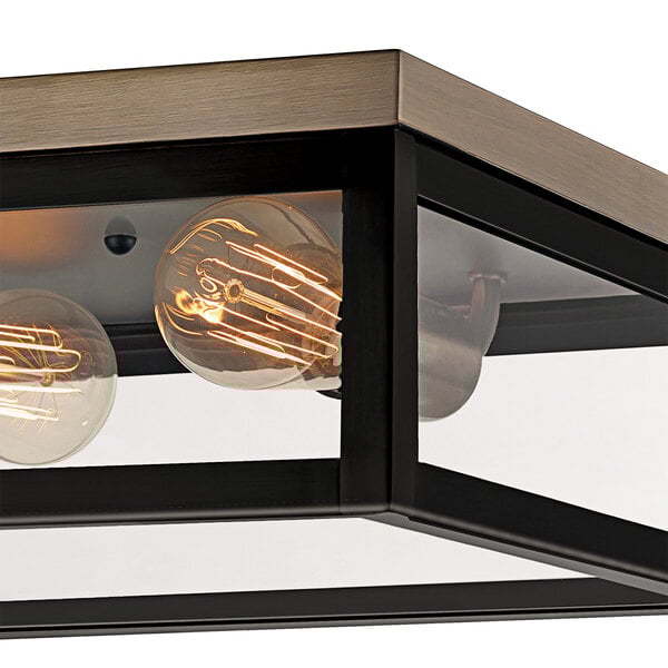 A dark bronze and antique brass flush mount light fixture with two bulbs.