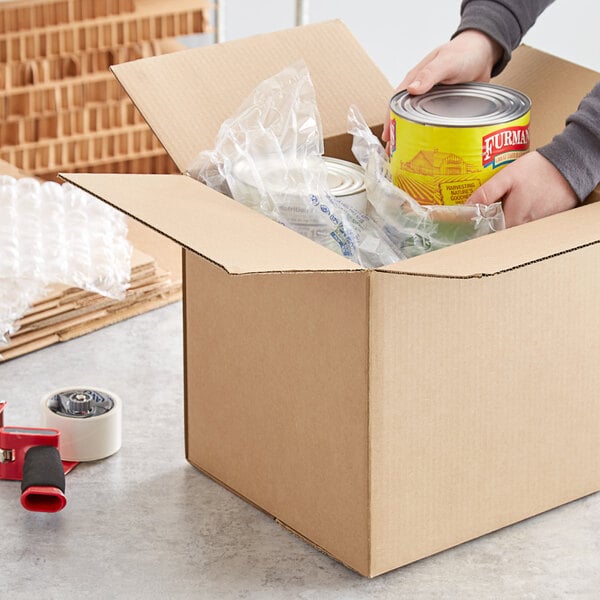 A person holding a can of food and a Lavex Kraft shipping box with a can of food inside.