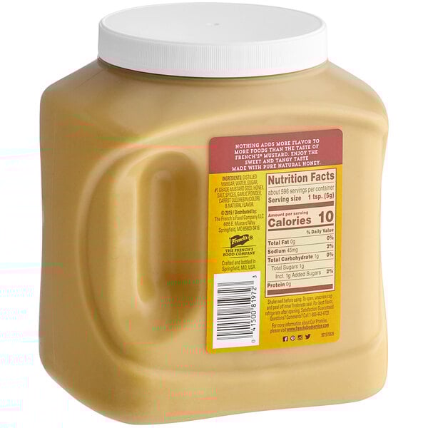 A jar of French's Honey Mustard Sauce on a counter.