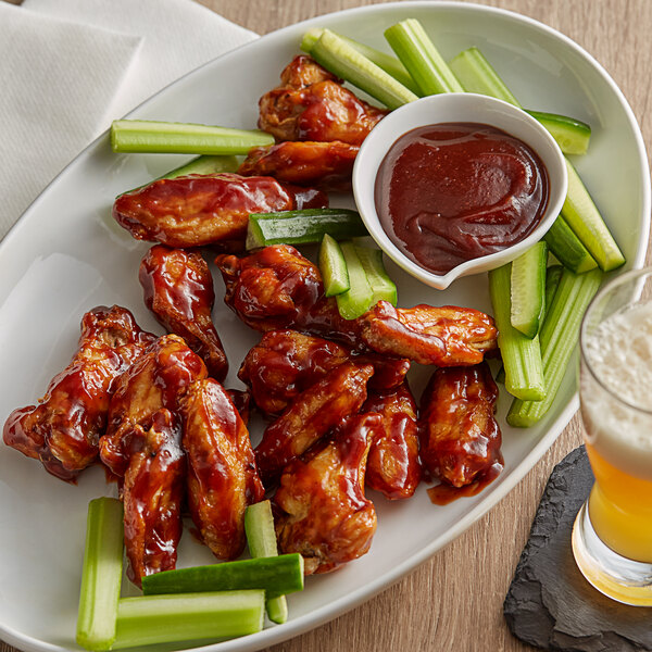 A plate of French's Smoky BBQ Sauce chicken wings and celery sticks.