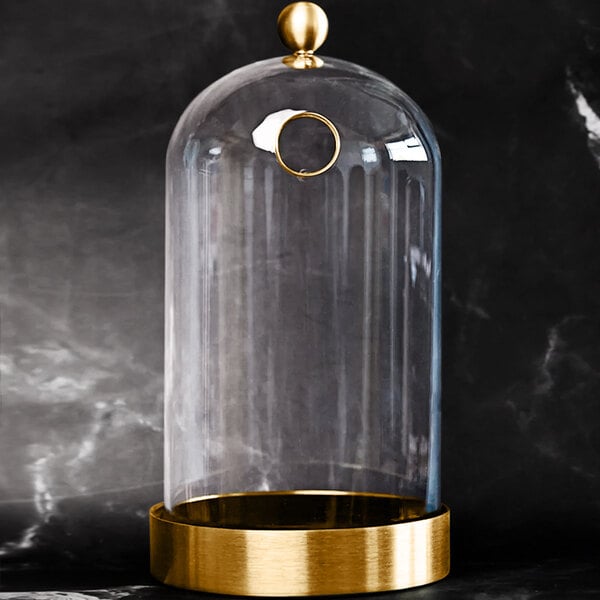 A Flavour Blaster large glass cloche with a gold base.