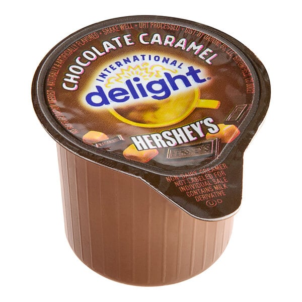 A brown International Delight container of Hershey's Chocolate Caramel non-dairy creamer.