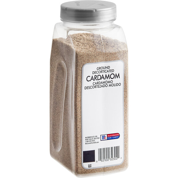 A plastic container of ground brown McCormick Culinary Ground Cardamom.